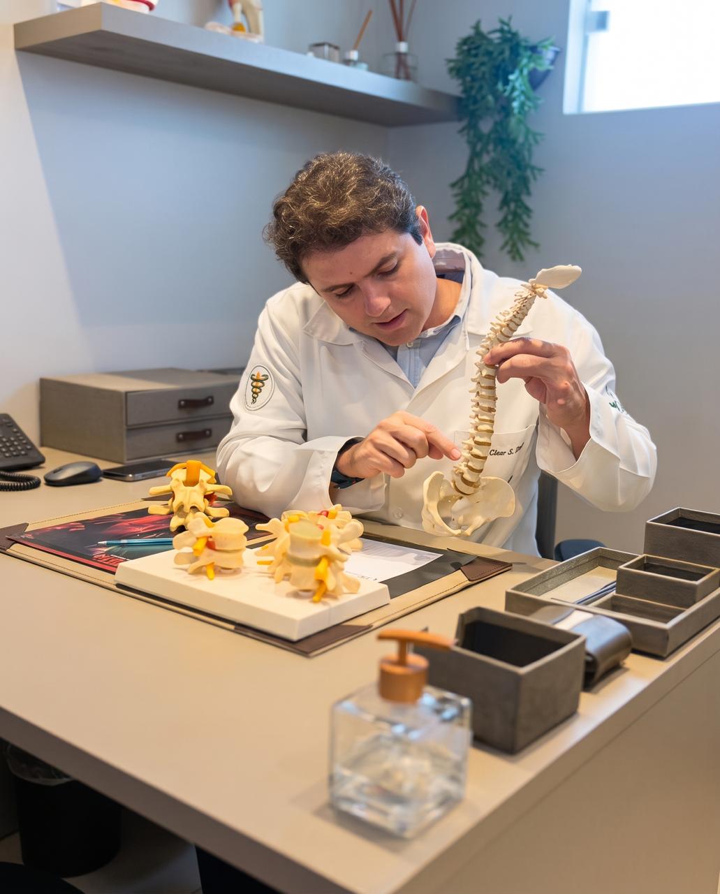 Fisioterapeuta explicando a coluna vertebral com modelo anatômico
